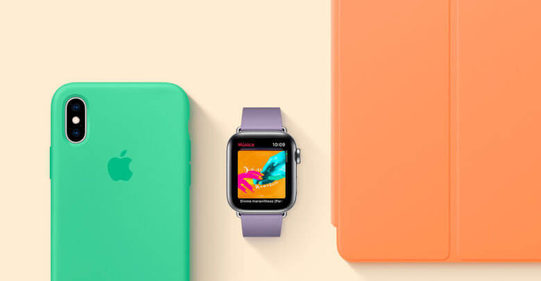 Foto de um iPhone com capa cor hortelã, um Apple Watch com pulseira Lilás e um iPad com capa frontal laranja