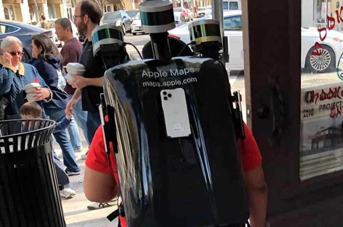 Foto de uma mochila especial cheia de câmeras, nas costas de uma pessoa
