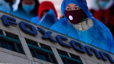Trabalhadora chinesa com máscara em uma fábrica da Foxconn