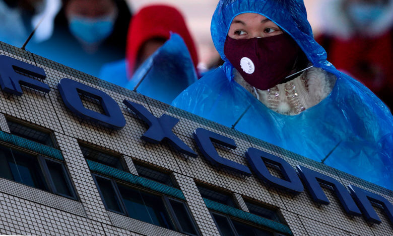 Trabalhadora chinesa com máscara em uma fábrica da Foxconn